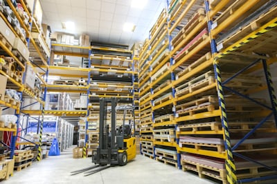 Warehouse aisle where ESL labels and pick-to-light guide an optimized multi-stop pick route
